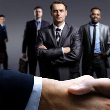 Image of businessmen in background and shaking hands